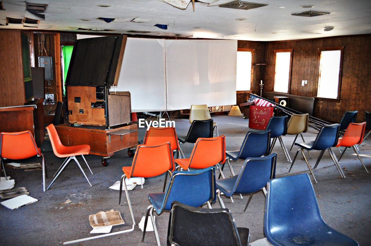 Abandoned interior with chairs and projection screen