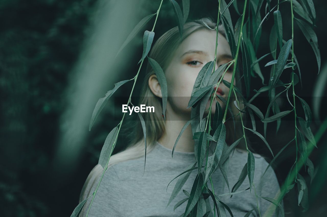 Portrait of woman standing by plants