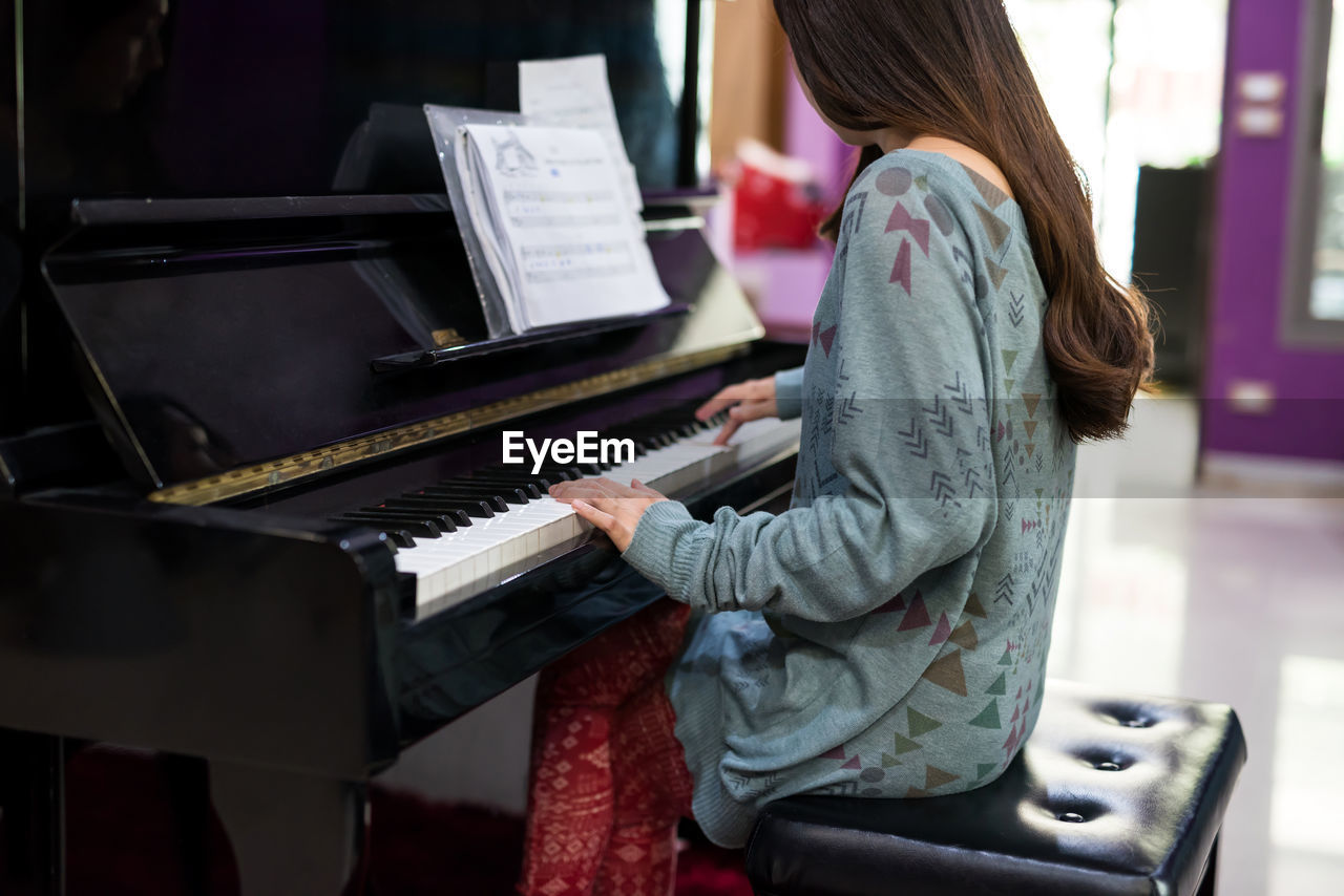 Midsection of woman playing piano