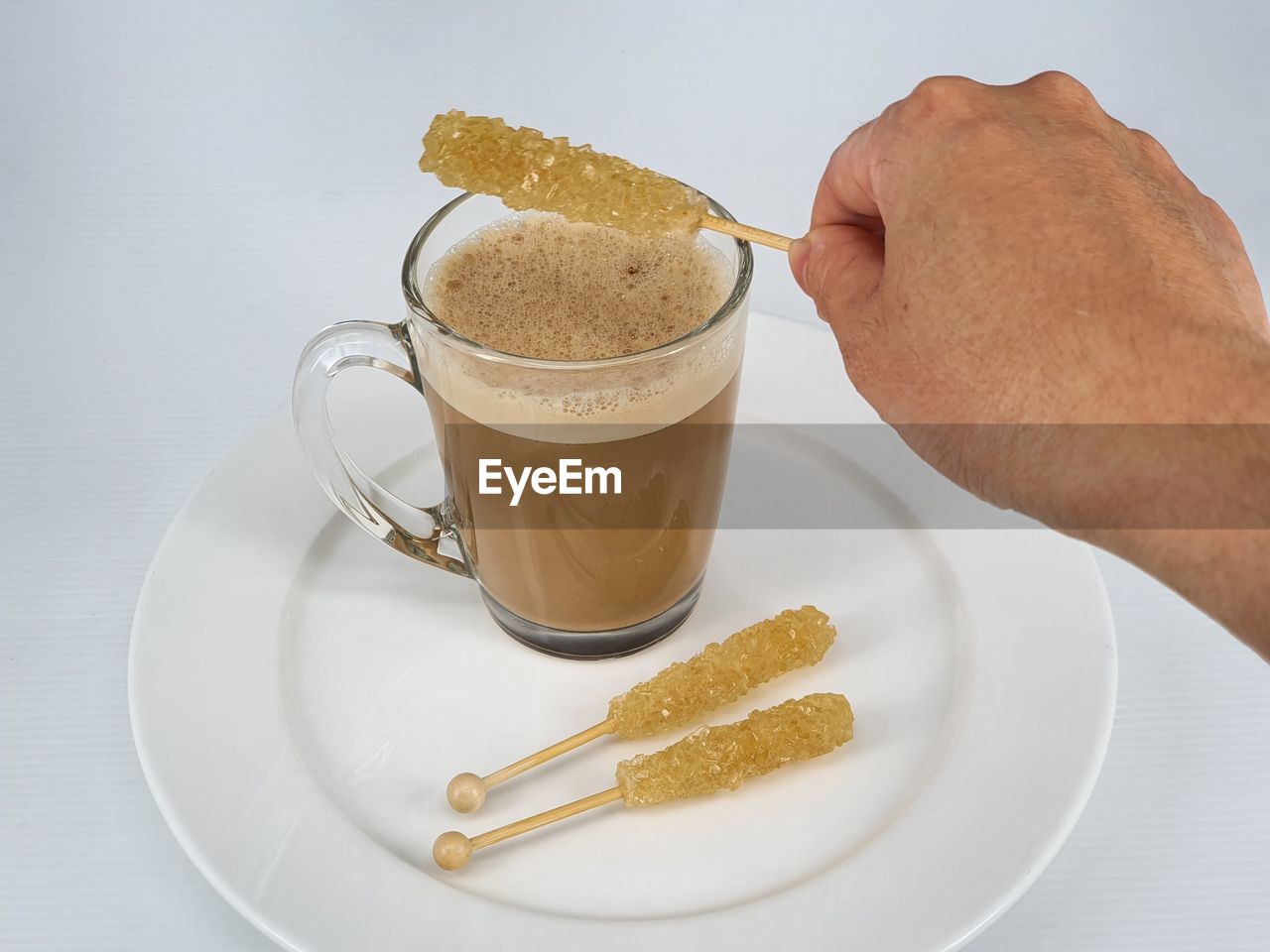 HIGH ANGLE VIEW OF HAND HOLDING COFFEE CUP AND DRINK