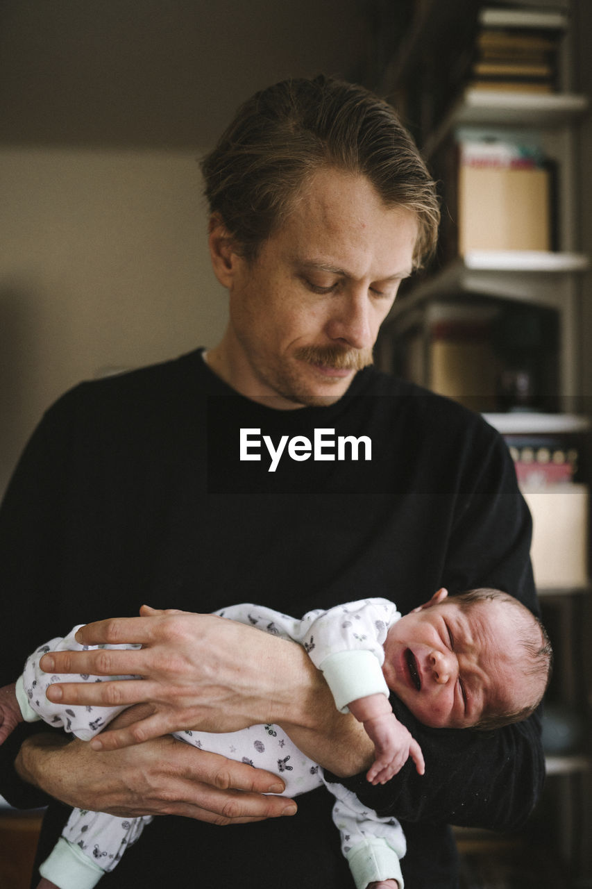 Father holding crying baby