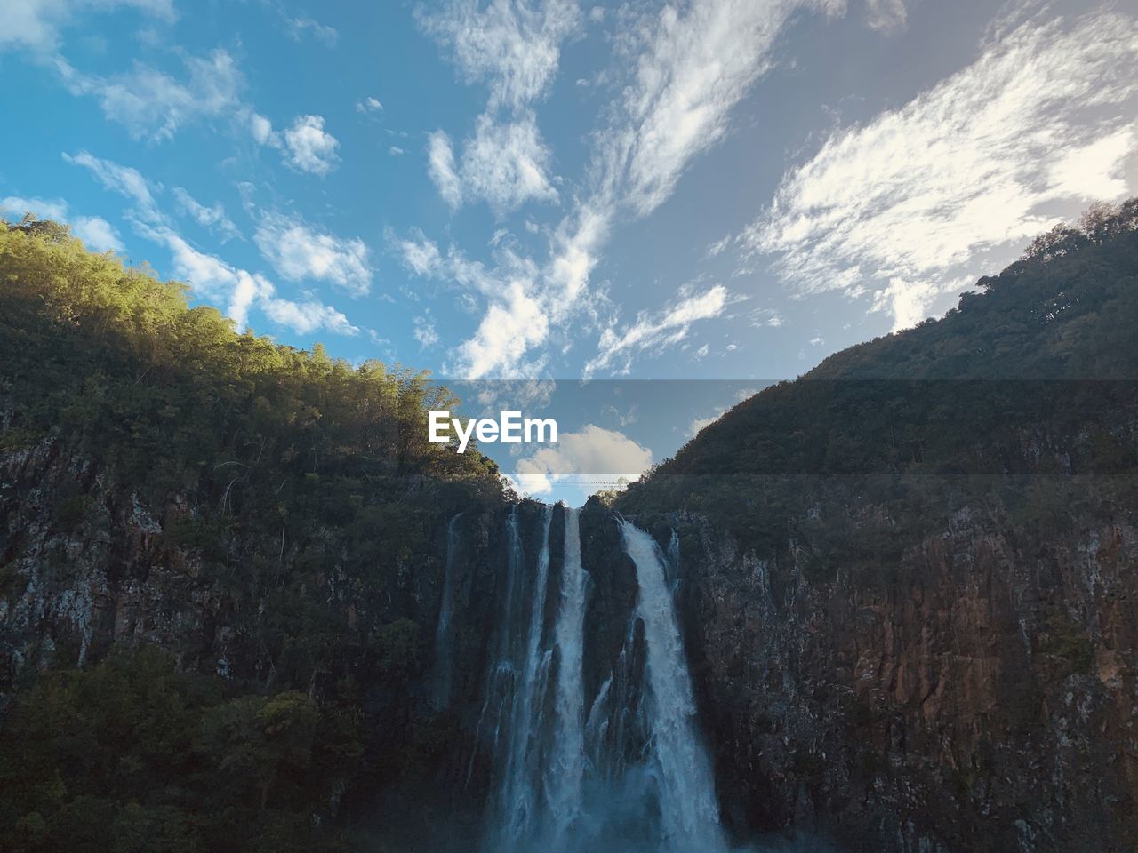 Low angle view of waterfall against sky