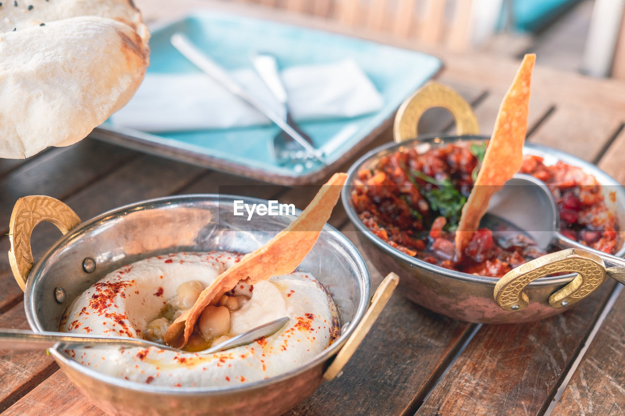 High angle view of hummus and spicy tomato salad on table