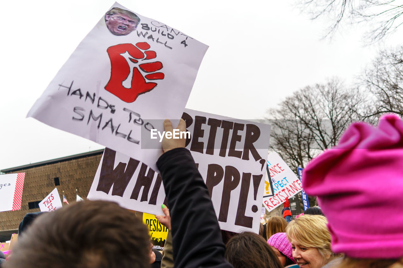 REAR VIEW OF PEOPLE WITH TEXT AGAINST THE WALL