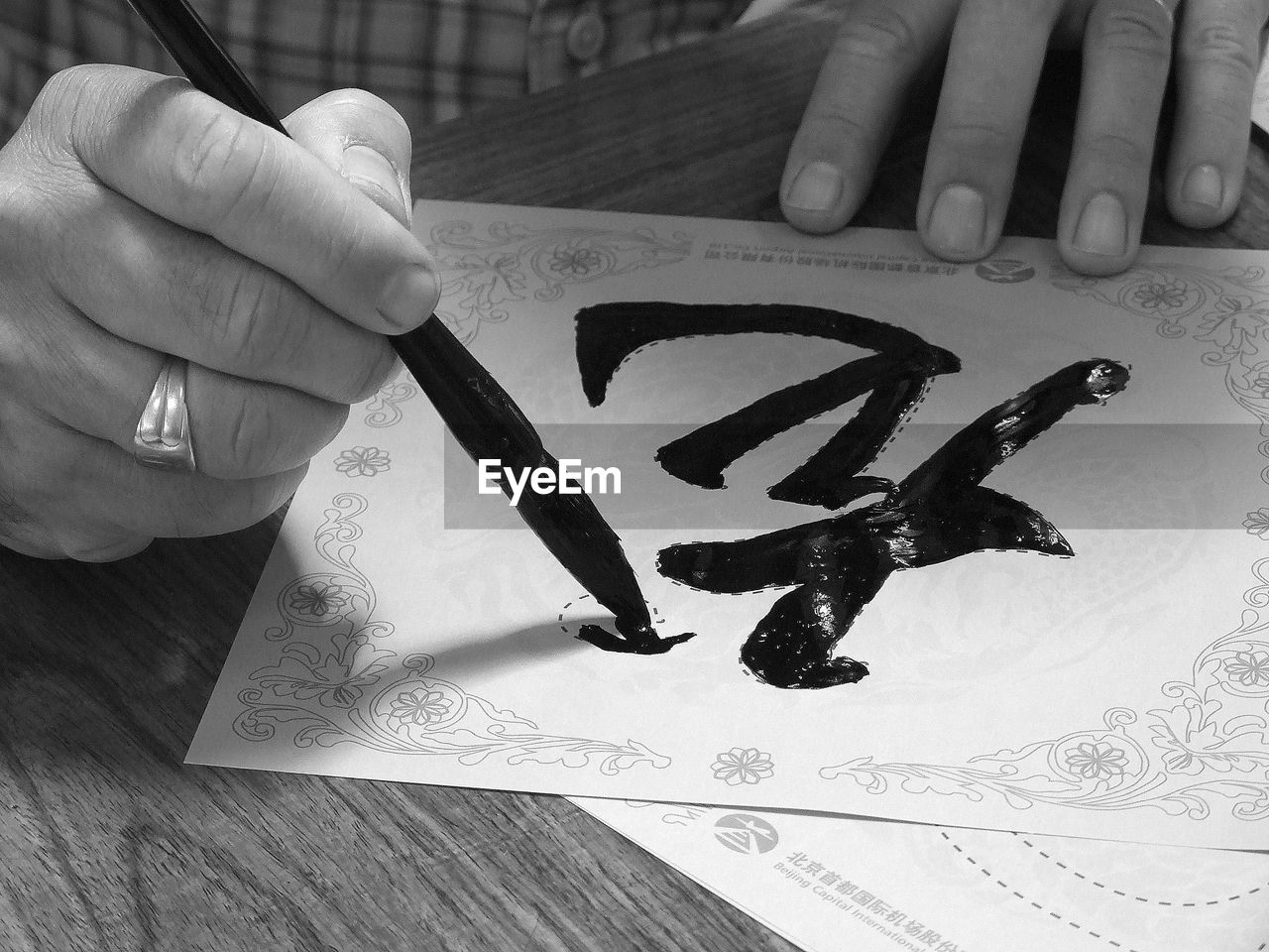 hand, black and white, drawing, calligraphy, monochrome photography, monochrome, one person, handwriting, white, sketch, paper, black, text, creativity, ink, indoors, finger, table, close-up, adult, holding, writing