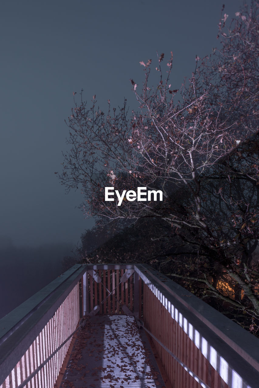 Footbridge against sky at night