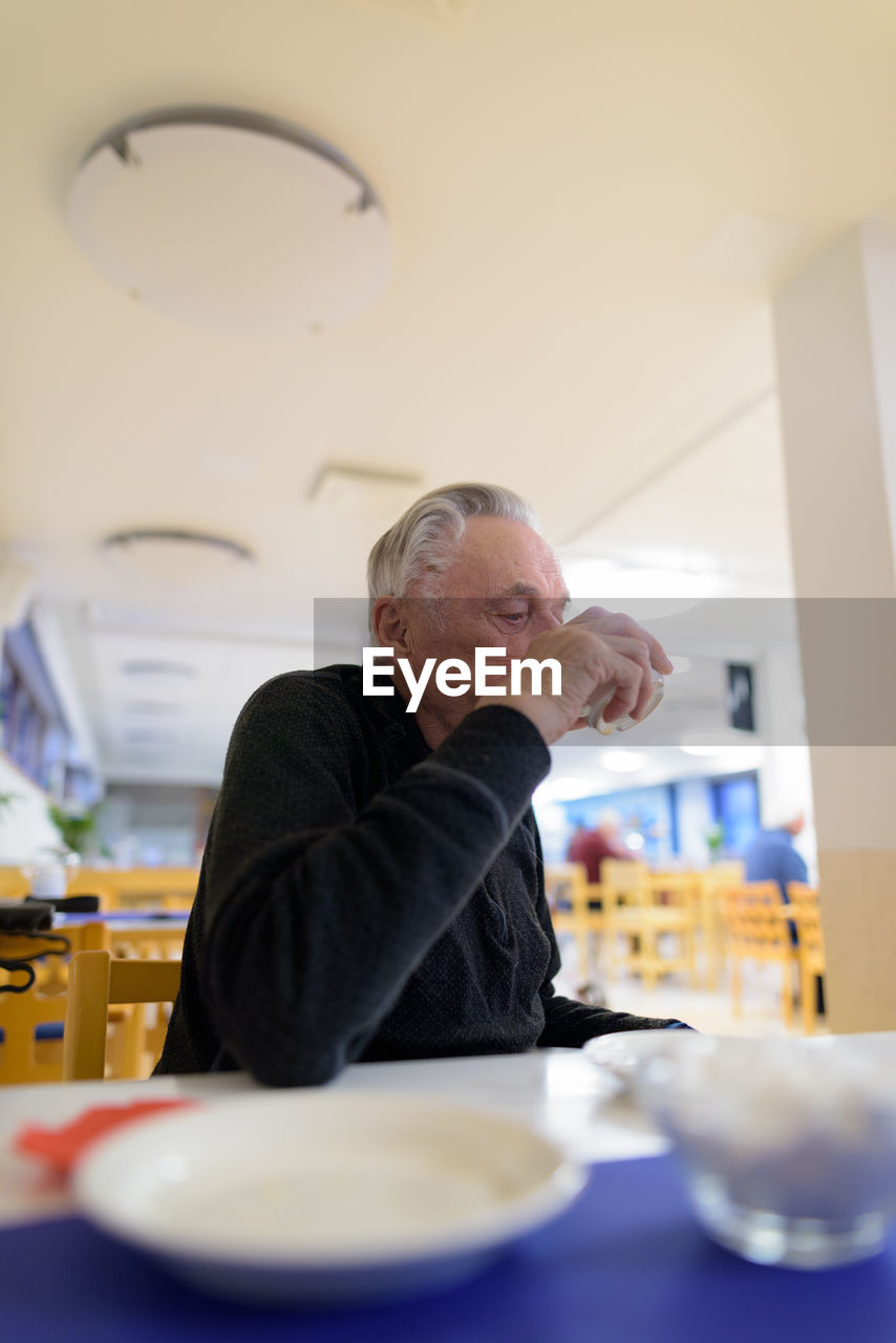 Portrait of a man sitting on table in restaurant