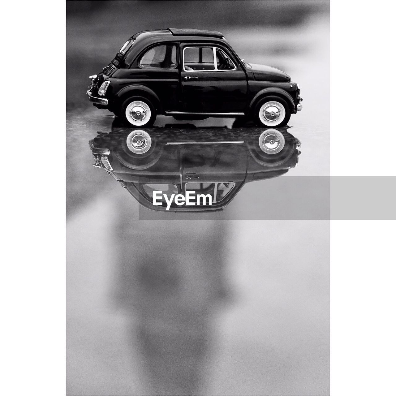 Close-up of toy car with reflection in puddle