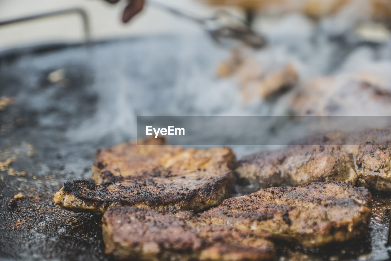 Close-up of steak frying in pan