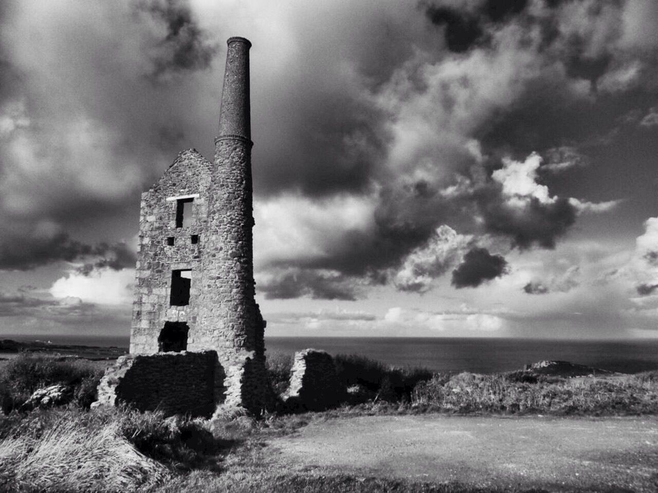 Stone tower against the calm sea and clouds