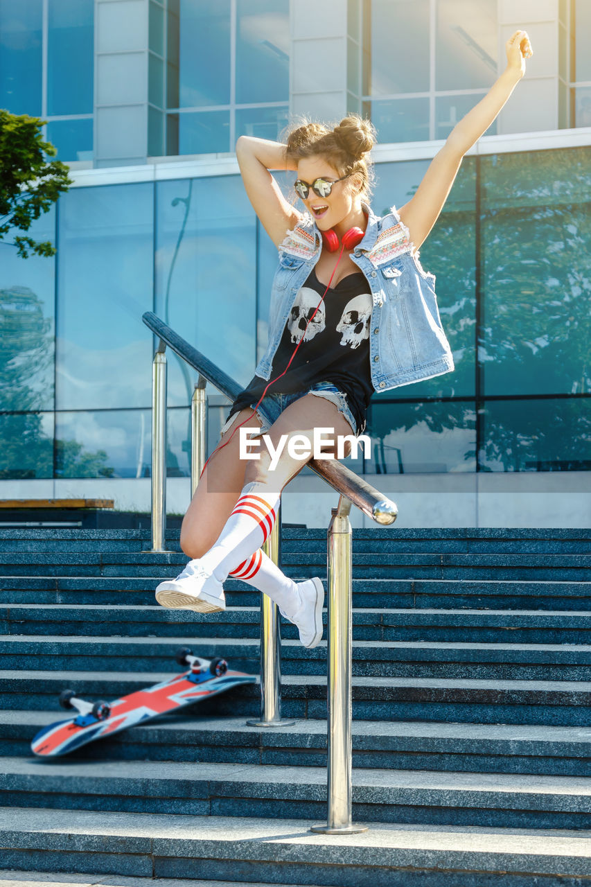 full length portrait of young woman exercising in city