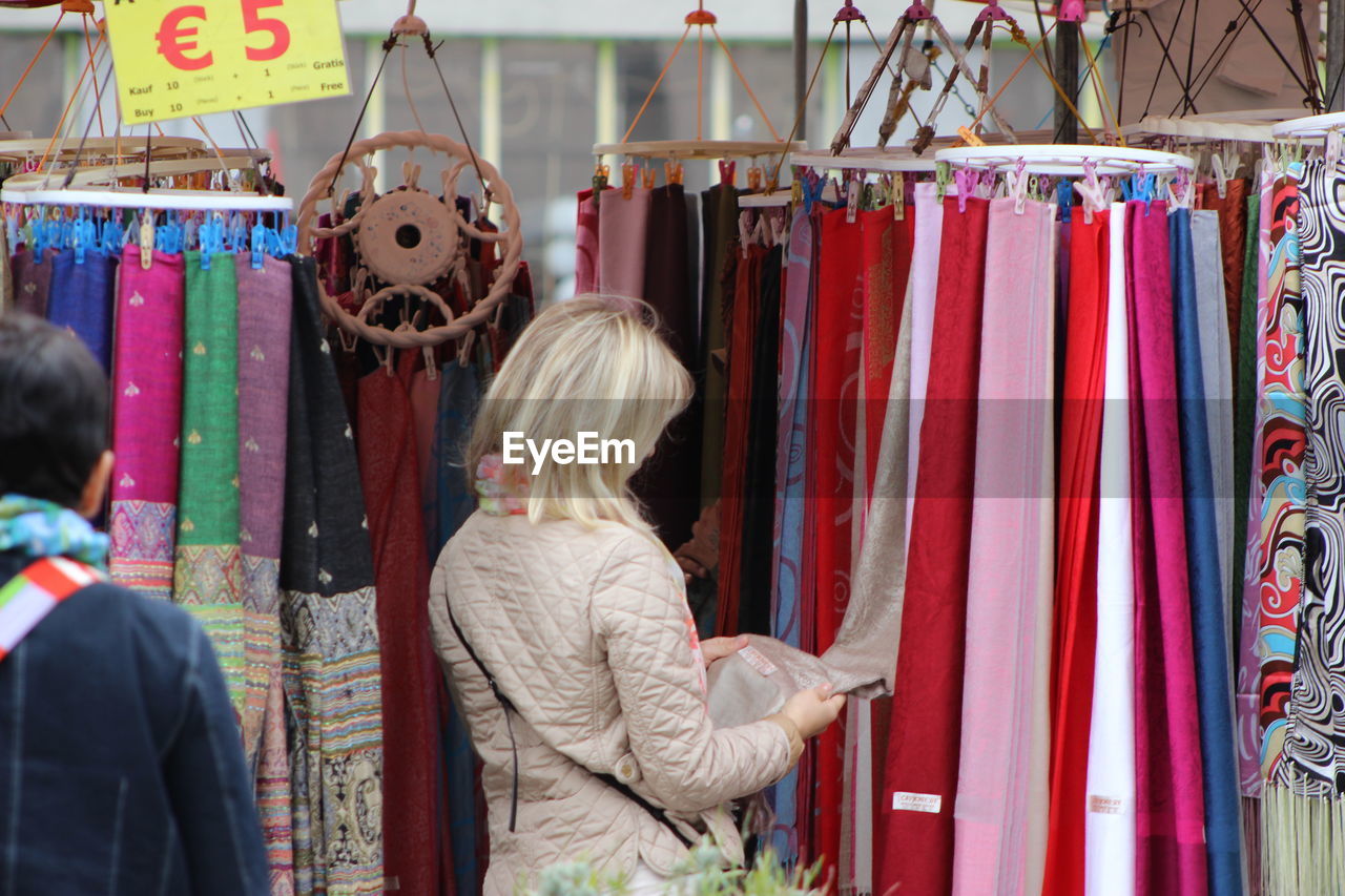 Rear view of man and woman at clothing stall