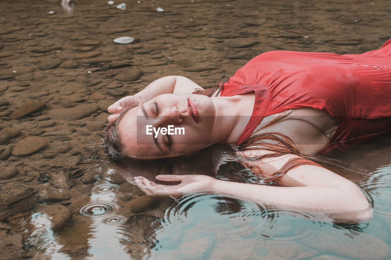 Woman lying in lake at forest