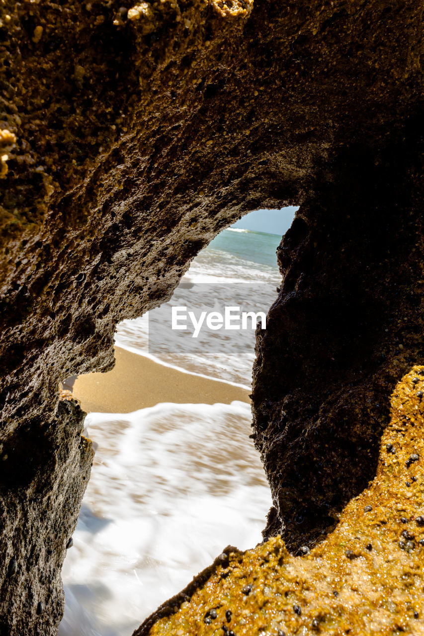 Close-up of rock formation by sea against sky