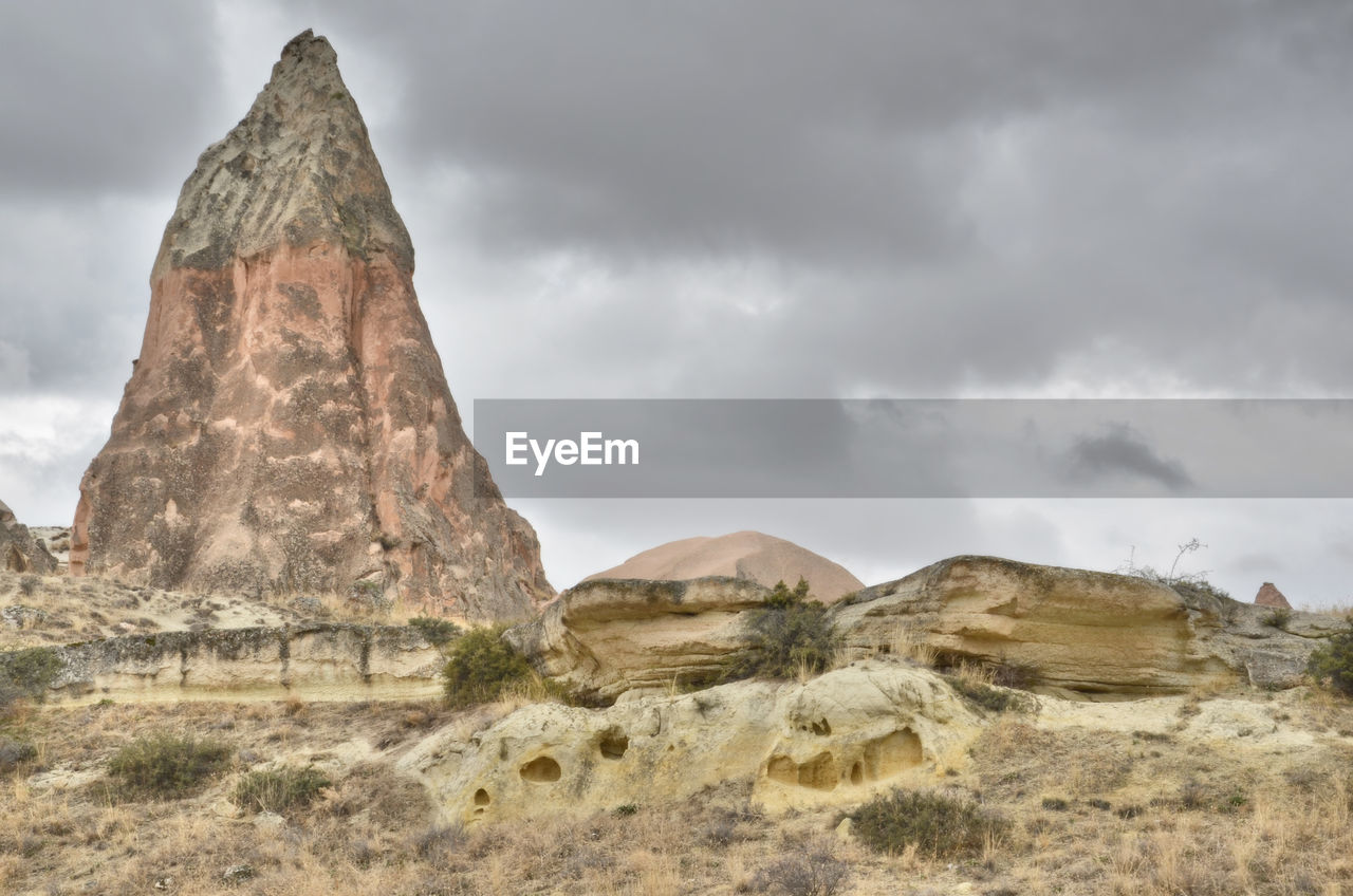 Rock formations on landscape against cloudy sky in kapadokya