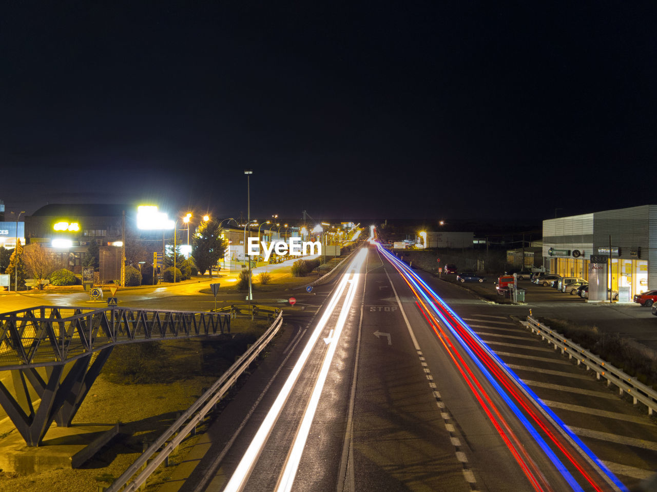 LIGHT TRAILS ON ROAD AGAINST SKY AT NIGHT