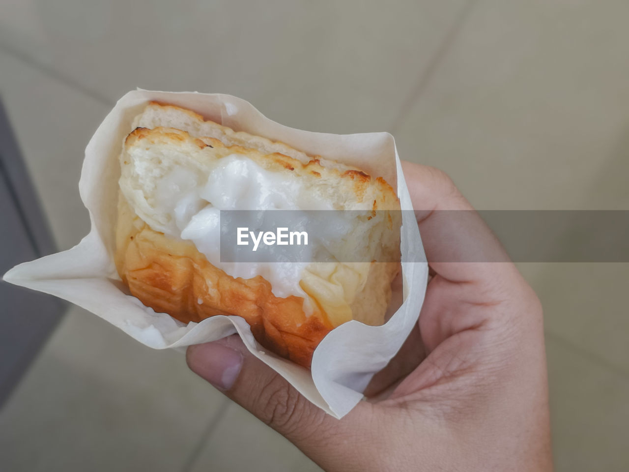 CLOSE-UP OF HAND HOLDING BREAD IN PLATE