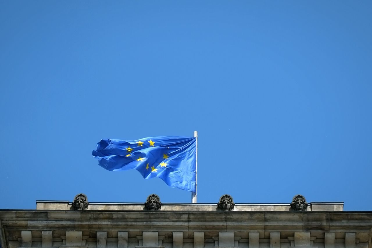 Low angle view of european union flag on building against clear sky