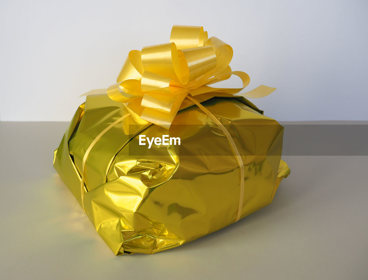 yellow, gift, surprise, gold, wrapped, paper, ribbon, studio shot, wrapping paper, box, bow, indoors, tied bow, celebration, gift box, present, no people, holiday, container, art, single object, christmas present, emotion, wealth, origami paper, petal, shiny, copy space, cut out, colored background, still life, origami