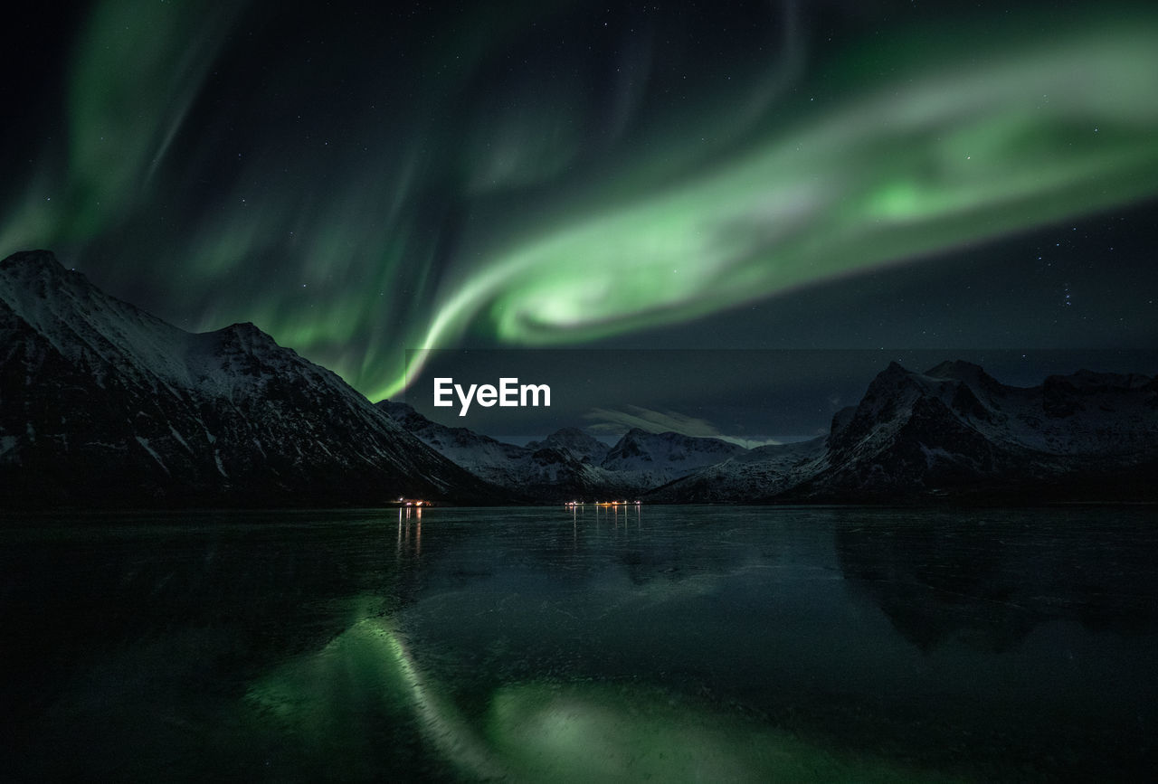 Scenic view of lake against sky at night