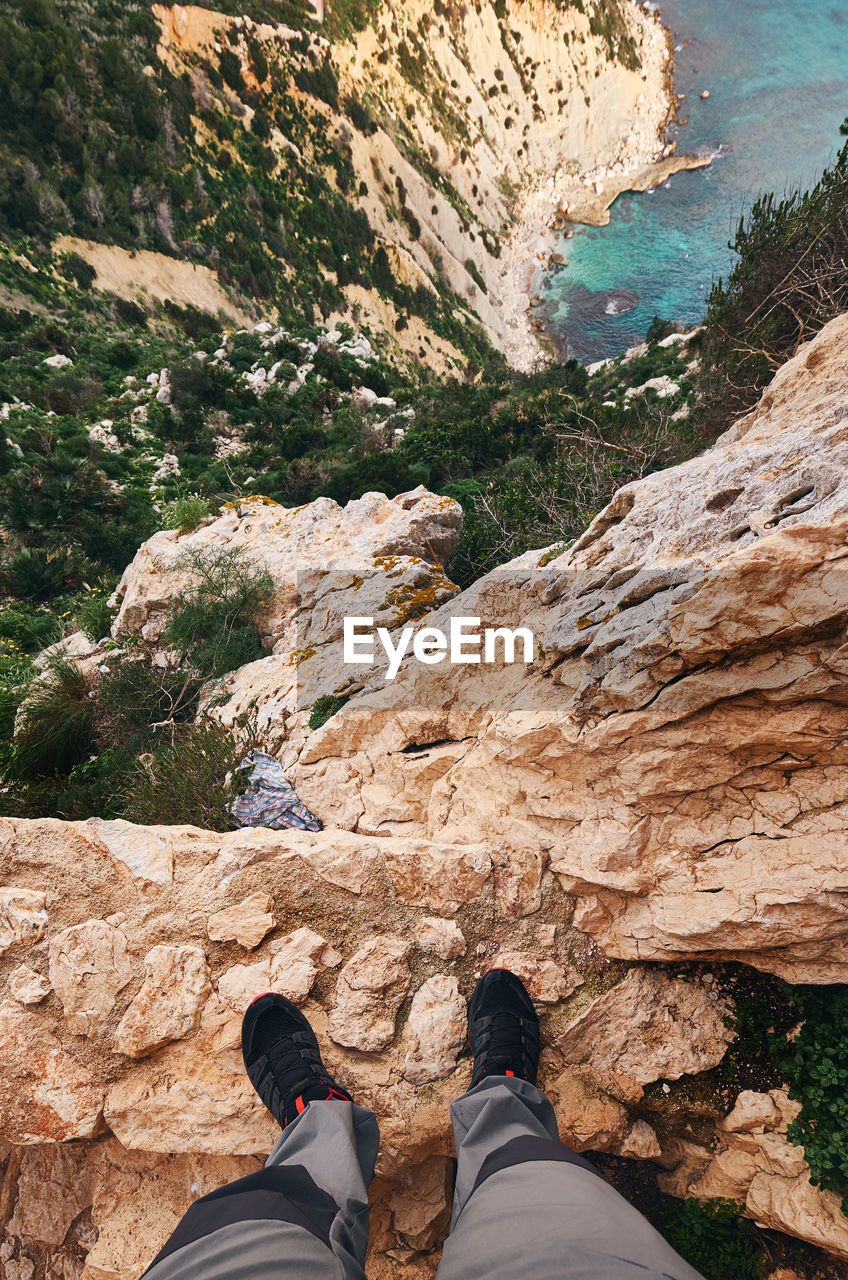 Low section of man standing on rock formation