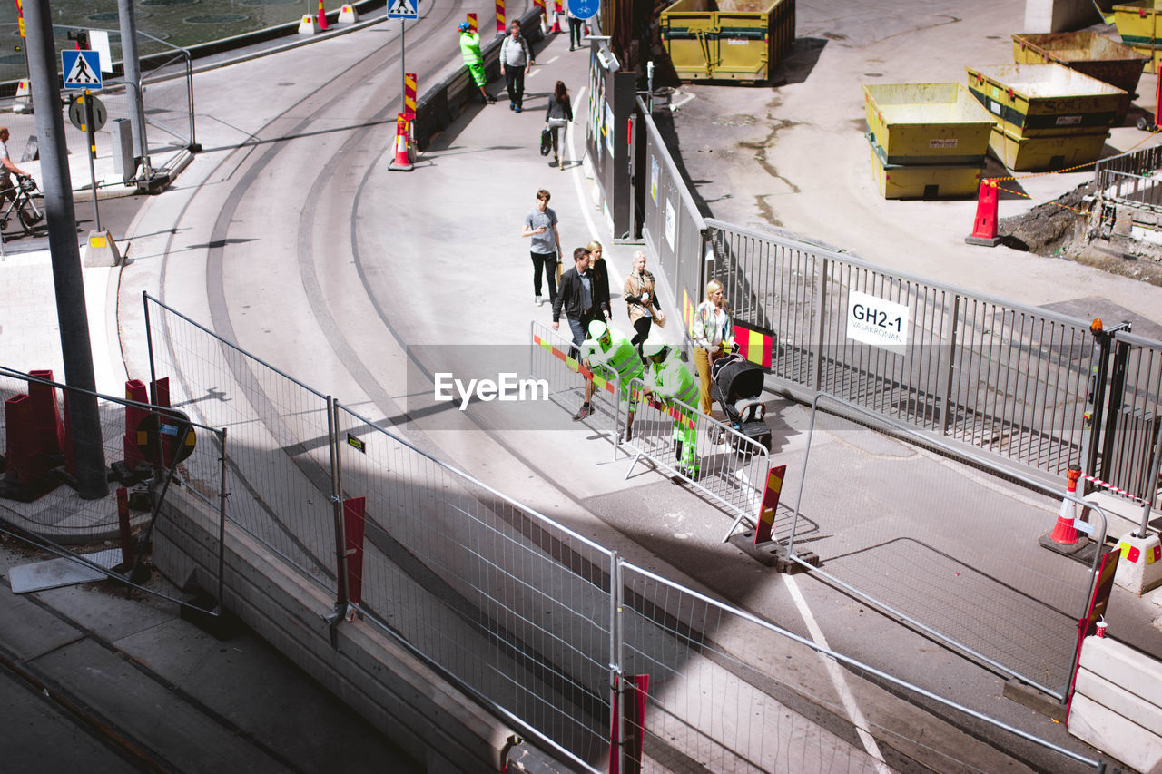 HIGH ANGLE VIEW OF PEOPLE WALKING ON STREET IN CITY