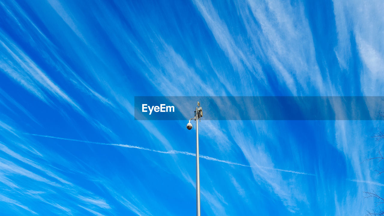 Low angle view of security camera against blue sky