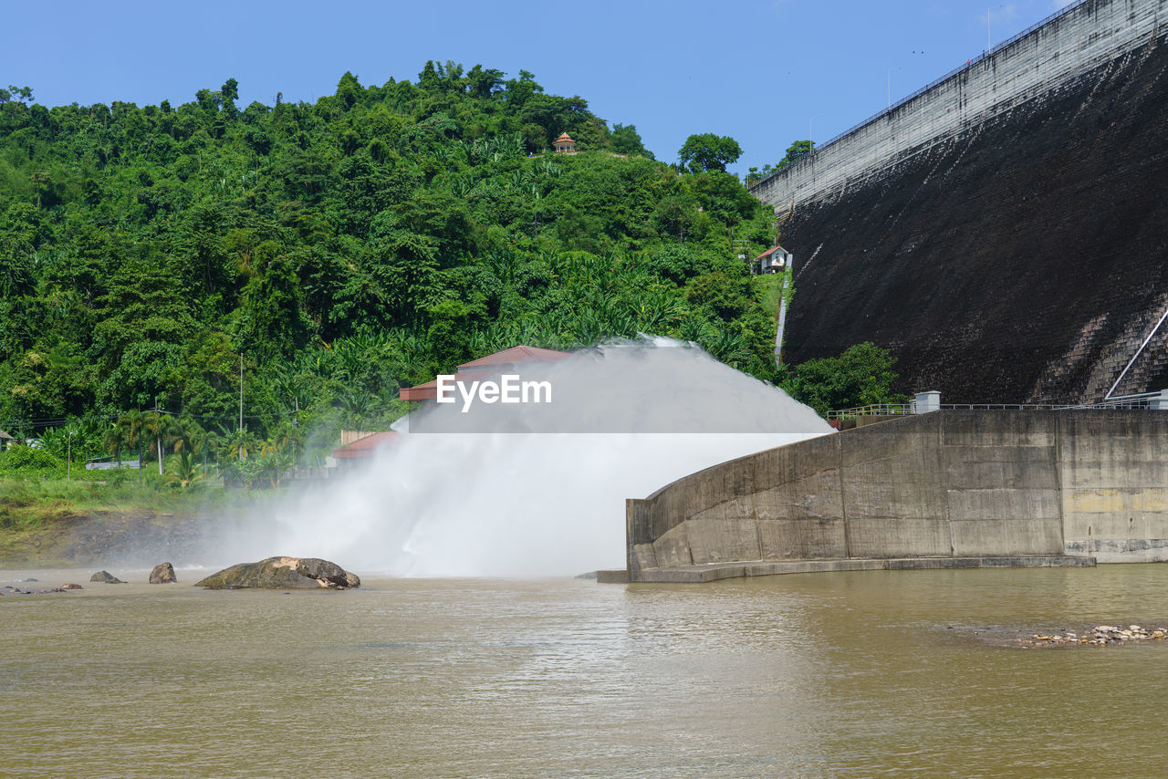 water, waterfall, nature, environment, river, tree, plant, beauty in nature, water feature, scenics - nature, travel destinations, reservoir, travel, tourism, body of water, architecture, no people, motion, outdoors, sky, environmental conservation, land, dam, landscape, built structure, day, mountain, social issues