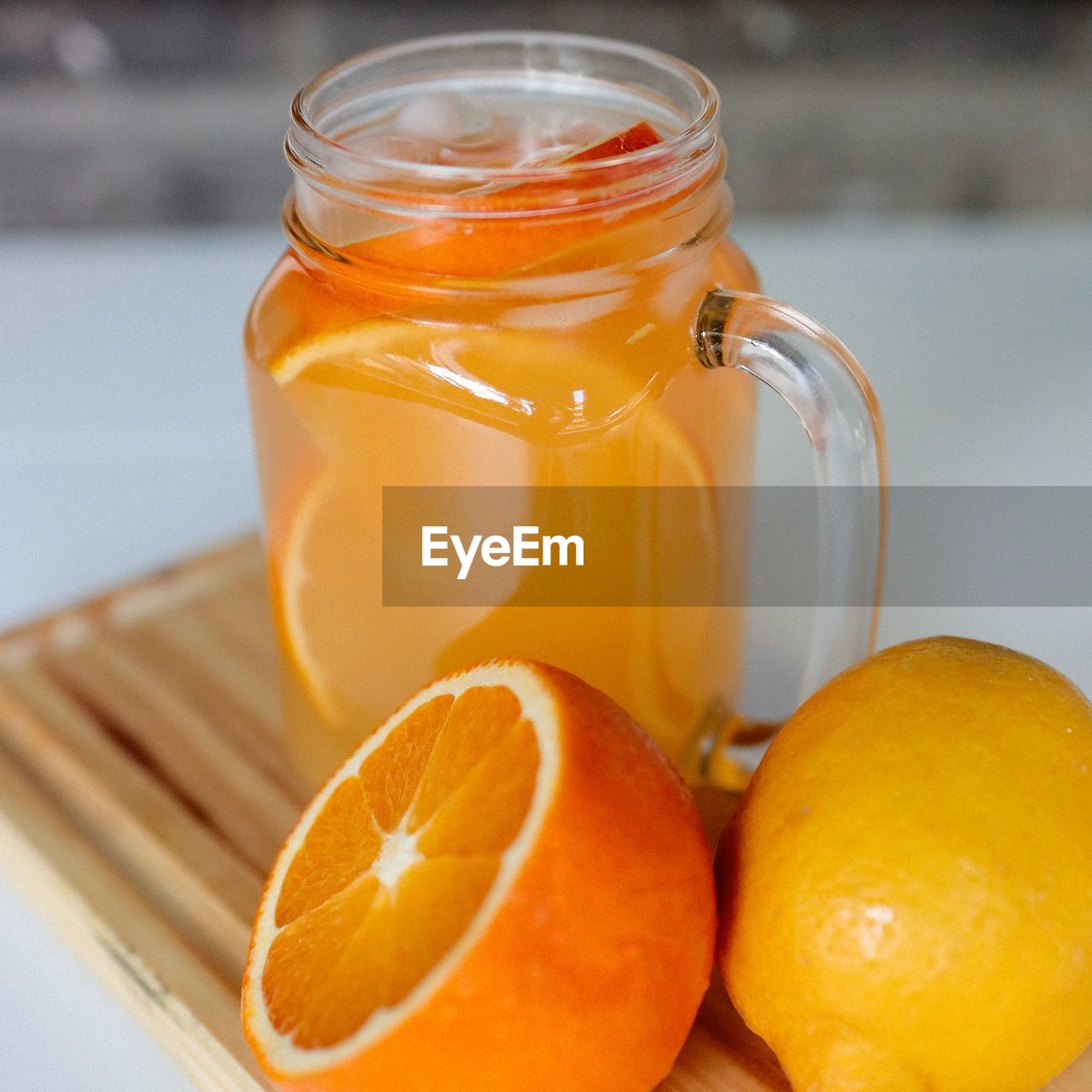 Close-up of oranges and lemonade in glass jar on table