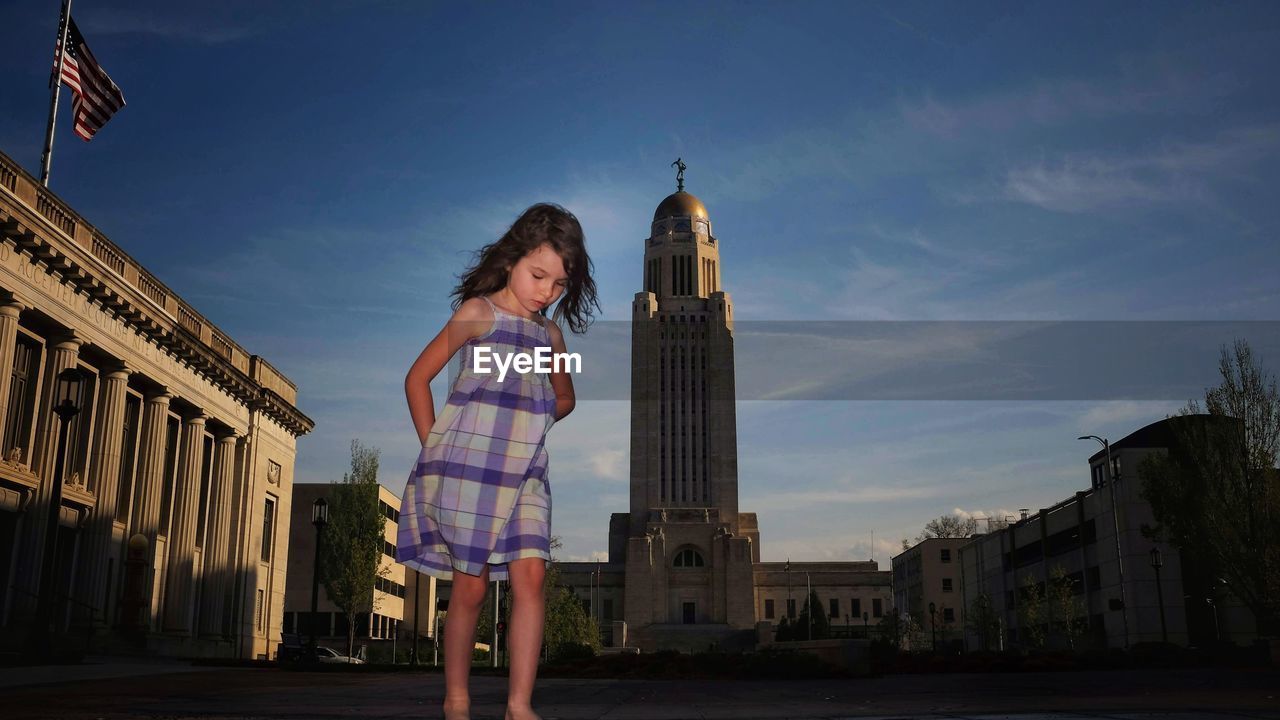 Girl standing against nebraska state capitol building 