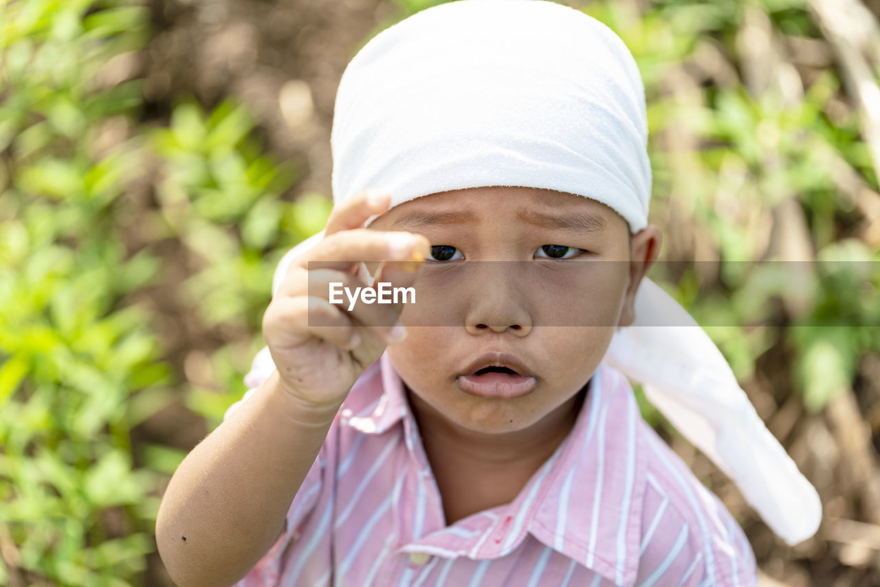 Portrait of boy standing on field