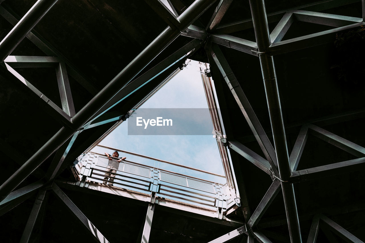 Low angle view of boy on bridge seen through ceiling