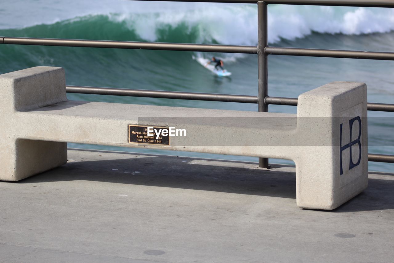 CLOSE-UP OF PERSON BY RAILING AGAINST SEA