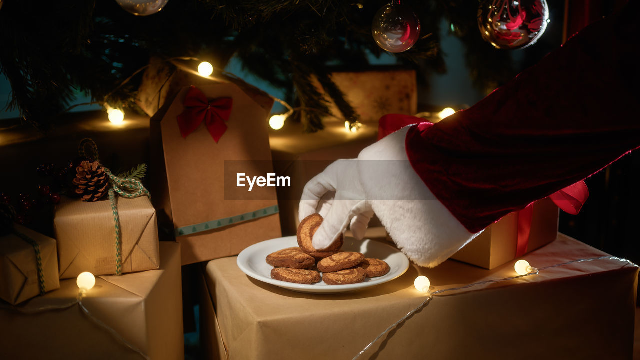 Santa claus takes biscuits under tree