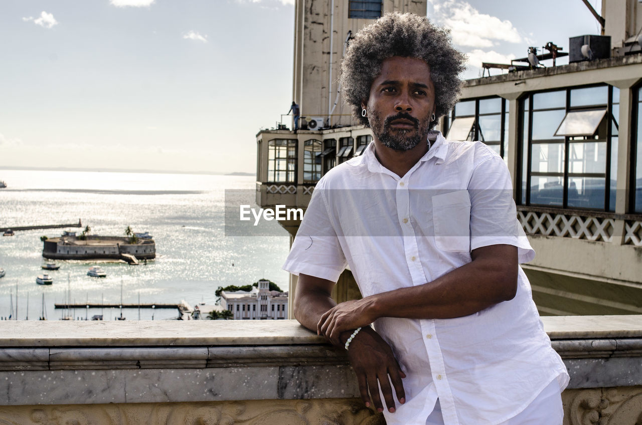 portrait of young man standing by sea