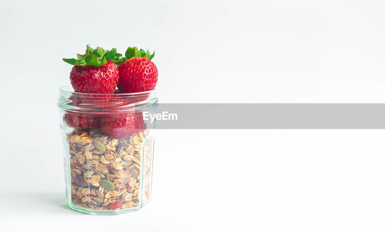 CLOSE-UP OF STRAWBERRIES IN GLASS JAR