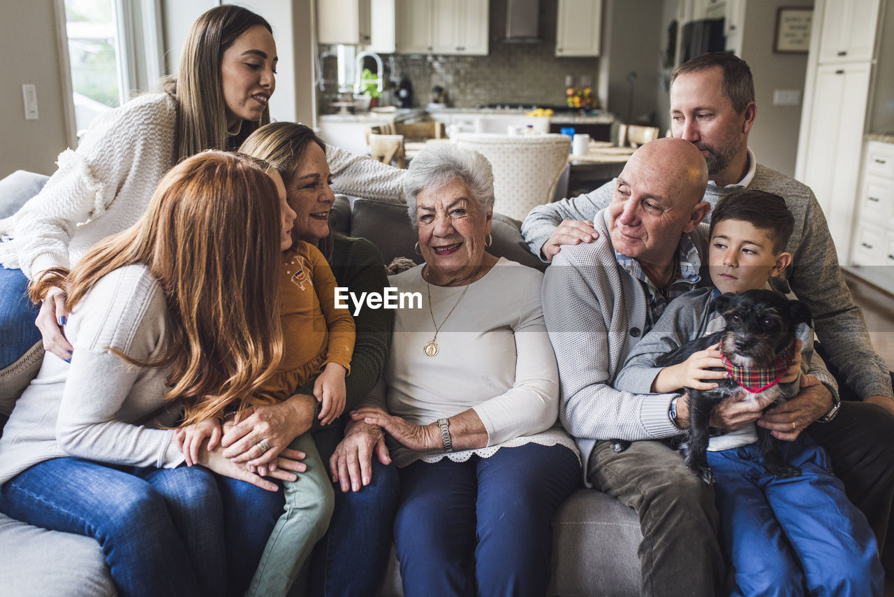 Portrait of multigenerational family sitting on living room couch