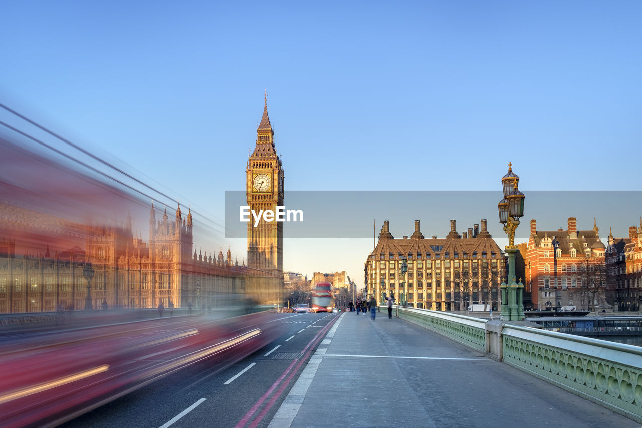 Double-decker bus passes on westminster bridge, in front of westminster palace and clock tower of big ben (elizabeth tower), london, england, united kingdom