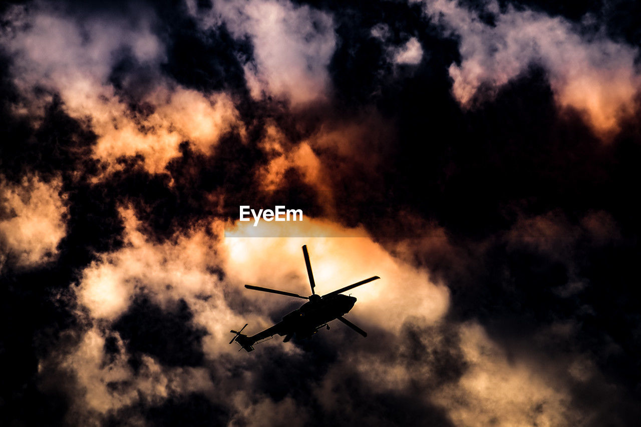 sky, cloud, darkness, air vehicle, flying, transportation, mode of transportation, silhouette, airplane, vehicle, nature, sunlight, helicopter, motion, sunset, aircraft, no people, on the move, mid-air, outdoors, military, dramatic sky, evening, smoke