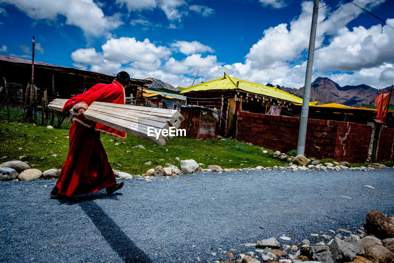 REAR VIEW OF WOMAN AGAINST SKY