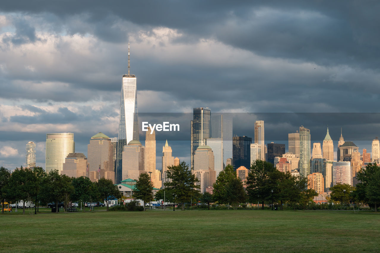 Buildings in city against cloudy sky