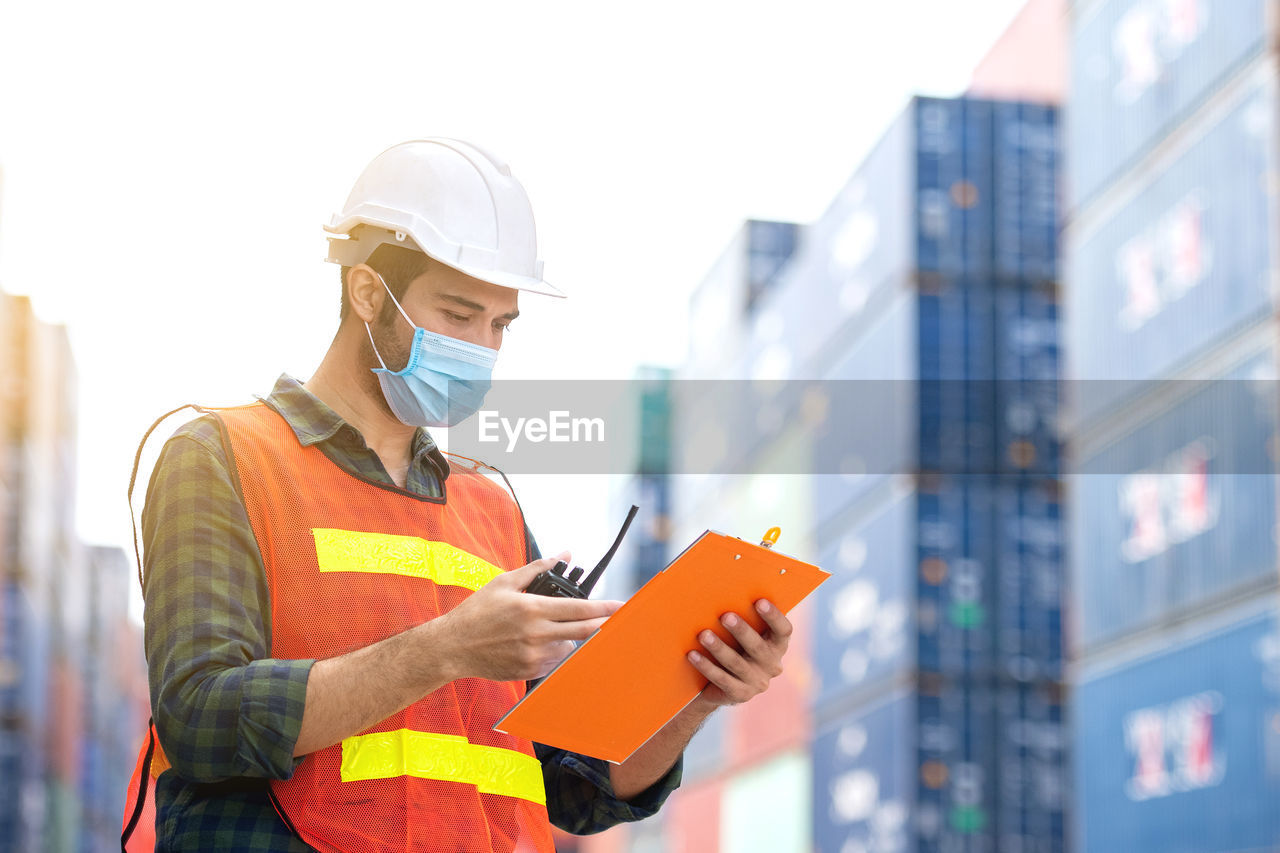 LOW ANGLE VIEW OF MAN WORKING WITH UMBRELLA