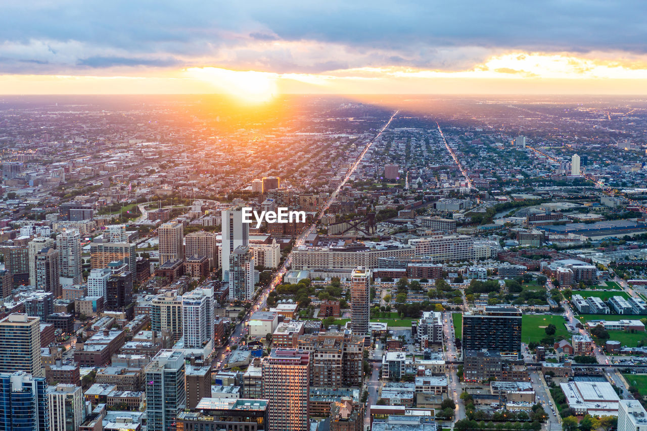 HIGH ANGLE VIEW OF BUILDINGS IN CITY AT SUNSET