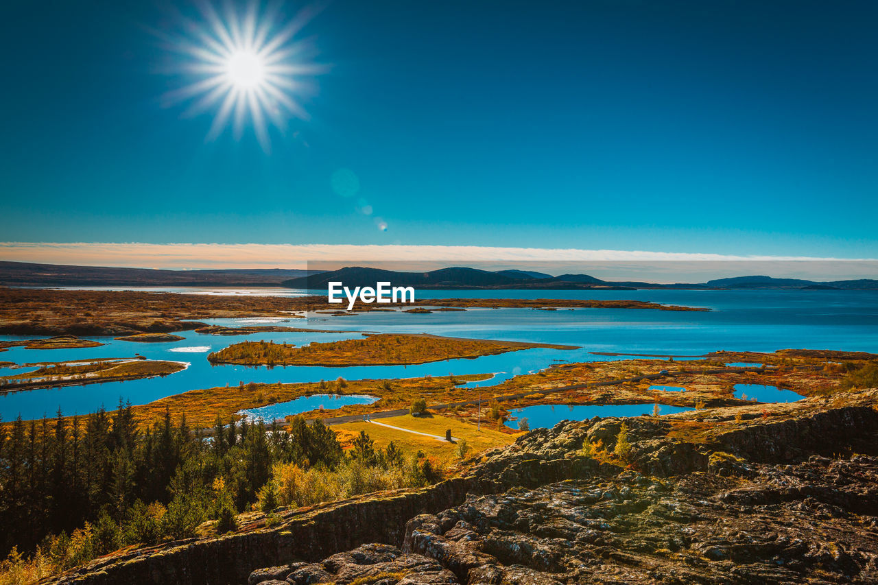 Scenic view of beach against sky during sunny day