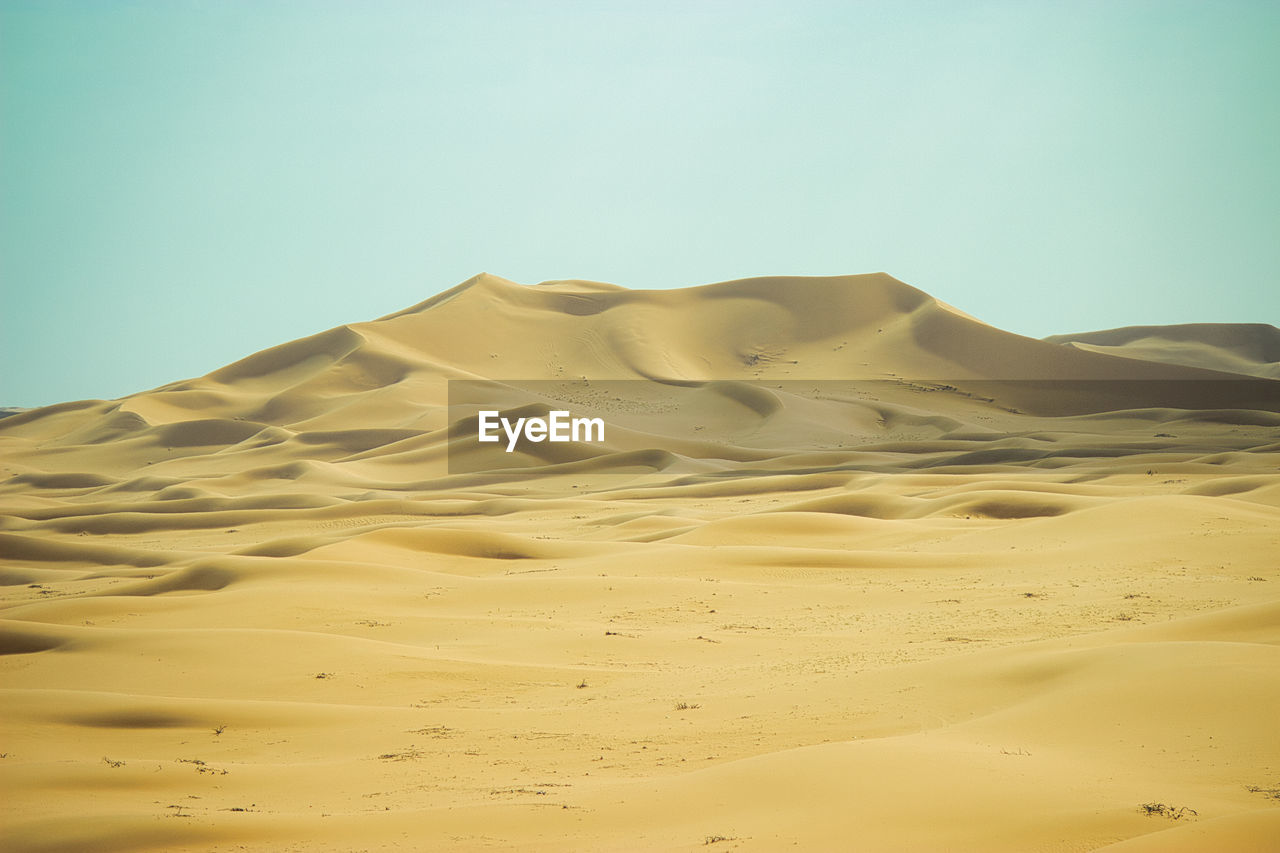 scenic view of desert against clear blue sky