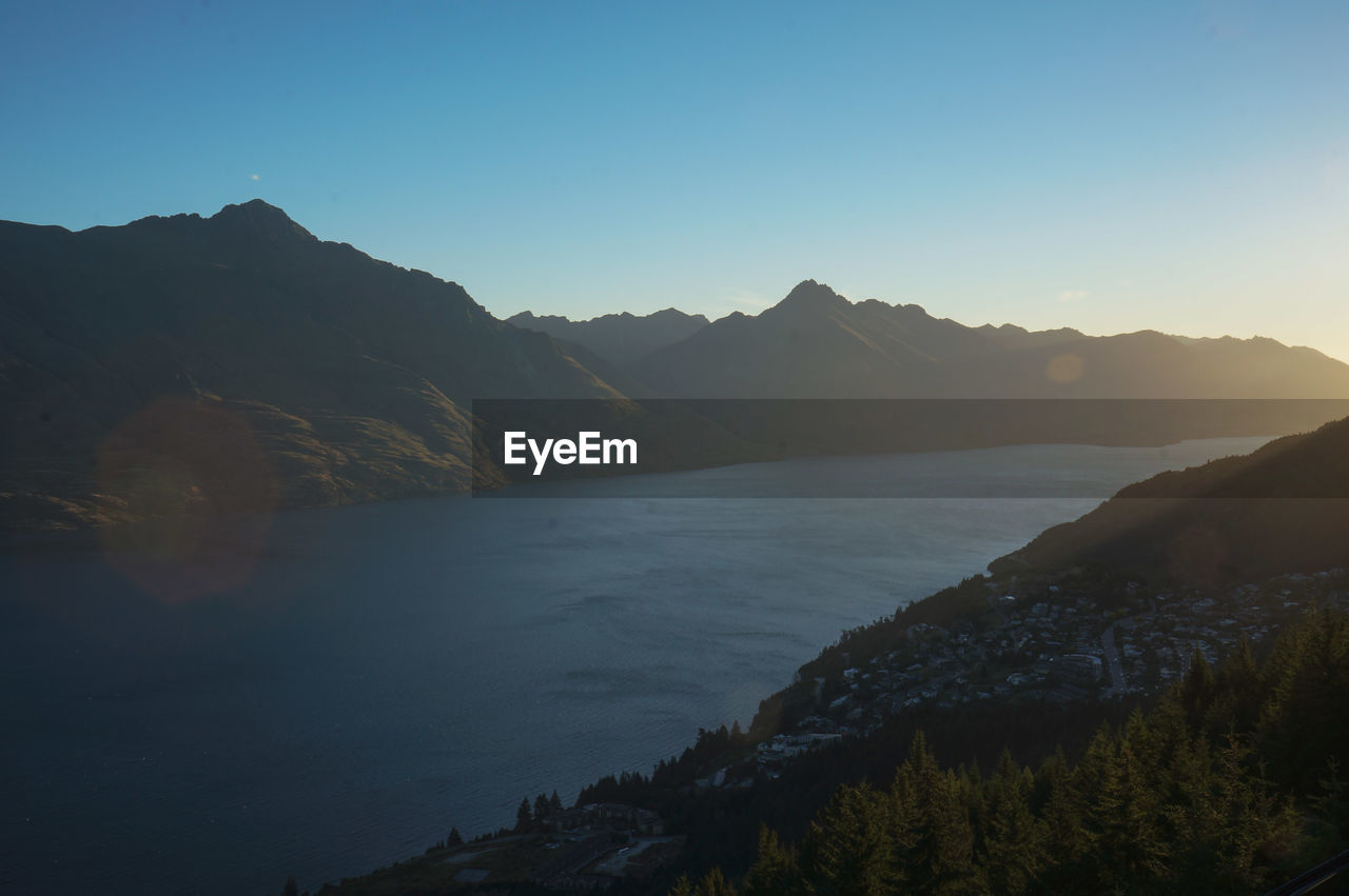 Scenic view of sea and mountains against clear sky