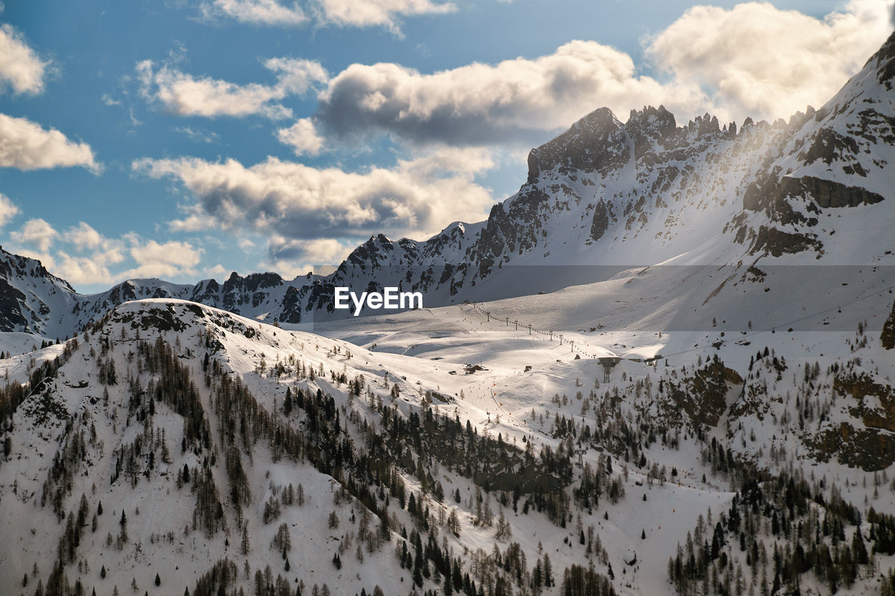 Peaceful rays of the evening sun shine over the ski slopes of the italian dolomites