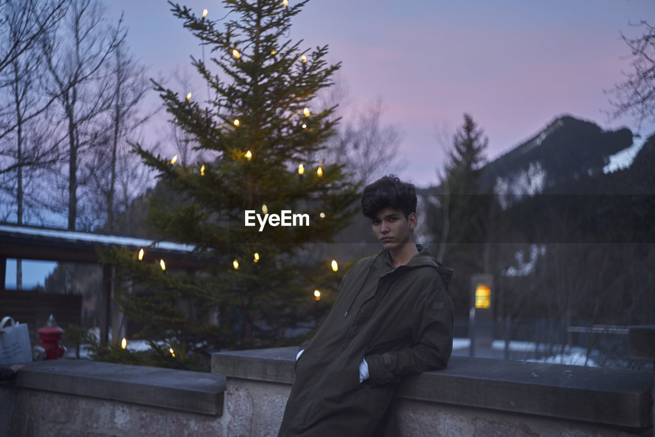 Man against christmas tree during sunset