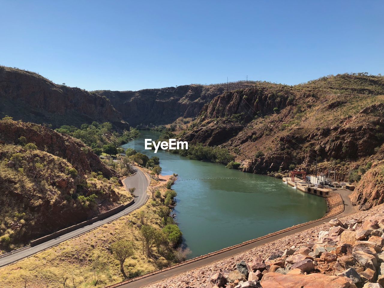 High angle view of river and mountains against clear blue sky