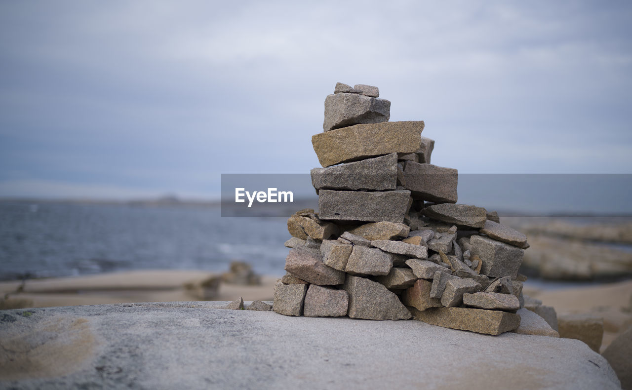 rock, sky, water, nature, sand, sea, land, beach, no people, balance, coast, tranquility, scenics - nature, cloud, outdoors, tranquil scene, beauty in nature, day, wood, shore, focus on foreground, ocean, stone, temple, environment